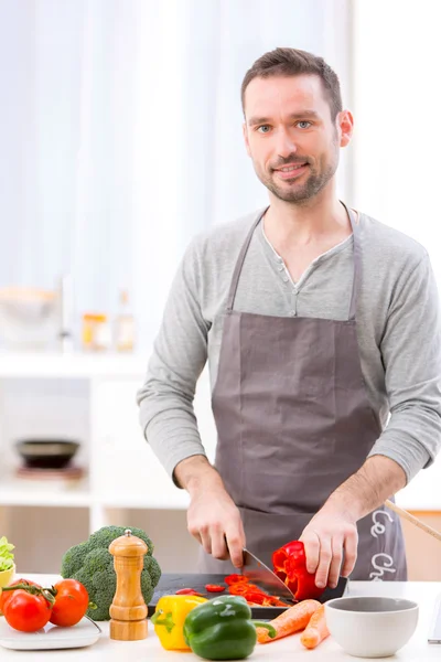 Junger attraktiver Mann kocht in einer Küche — Stockfoto