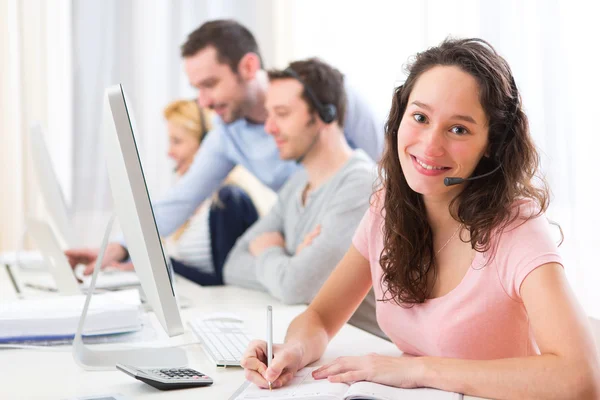 Giovane donna attraente che lavora in un call center — Foto Stock