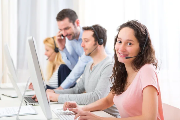 Jonge aantrekkelijke vrouw die werkt in een callcenter — Stockfoto