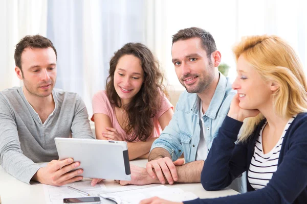 Gruppe von 4 jungen attraktiven Menschen, die an einem Laptop arbeiten — Stockfoto