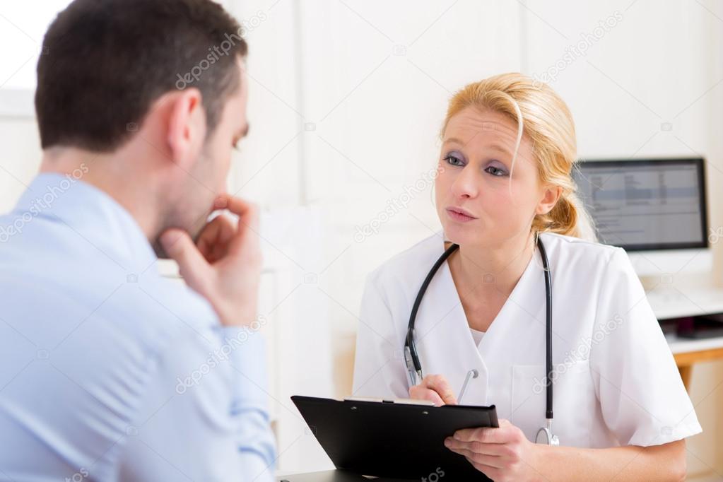 Young attractive doctor taking notes while patient speaking