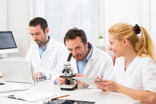 Equipo de científicos trabajando juntos en el laboratorio — Foto de Stock