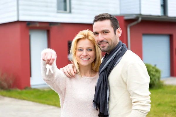 Joven pareja feliz en frente de su nueva casa — Foto de Stock