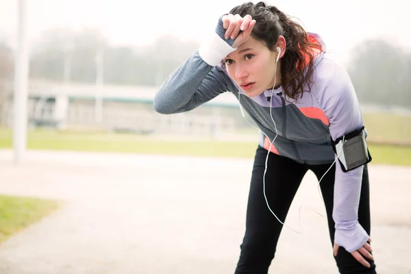 Young attractive woman stretching after a running session — Stock Photo, Image