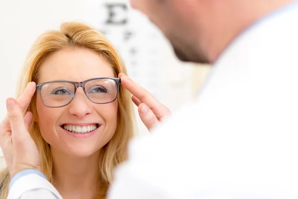 Young attractive woman trying glasses w optician — Stock Photo, Image
