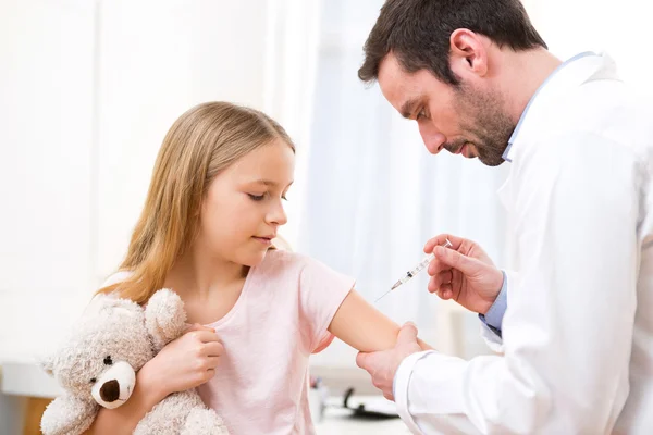 Niña joven siendo vacunada en el médico — Foto de Stock