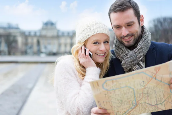 Paar van jonge aantrekkelijke toeristen kijken kaart — Stockfoto