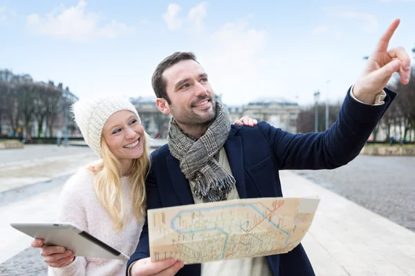 Couple of young attractive tourists watching map — Stock Photo, Image