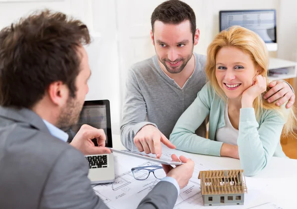 Real estate agent present project on tablet to a young couple — Stock Photo, Image