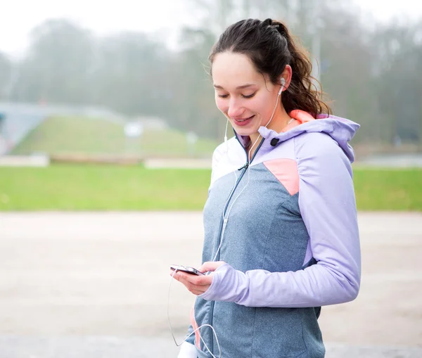 Young attractive woman adjust her music player before running — Stock Photo, Image