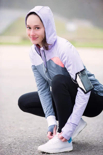 Fiatal, vonzó nő odakötő cipőfűzők előtt futó munkamenet — Stock Fotó