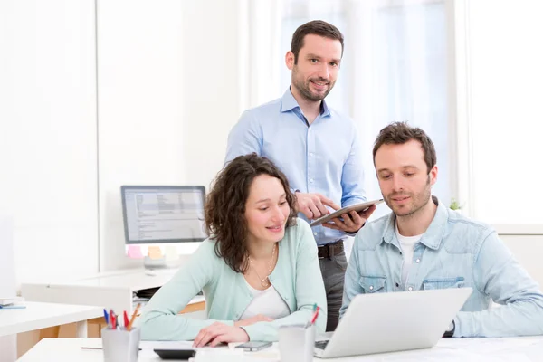 Zwei Praktikanten, die gemeinsam mit ihrem Kursleiter arbeiten — Stockfoto