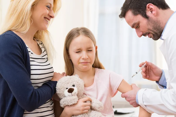 Jonge meisje begeleid door haar moeder wordt ingeënt — Stockfoto