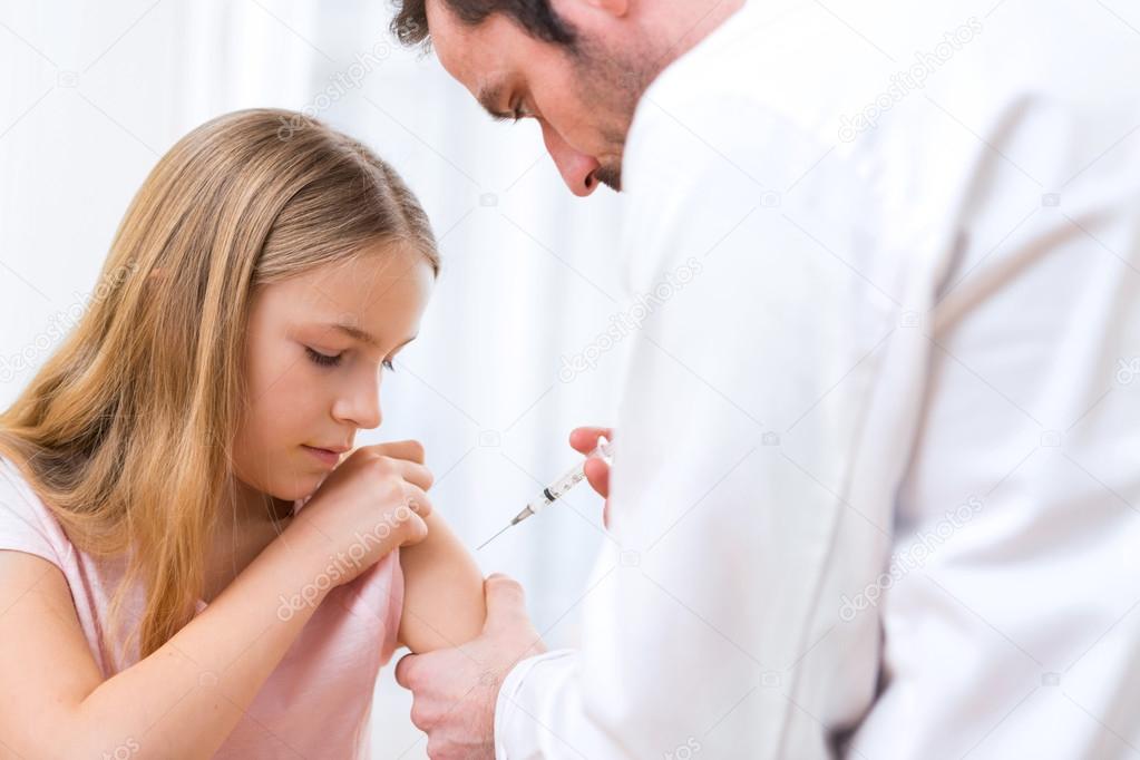 Young little girl  being vaccinated at the doctor