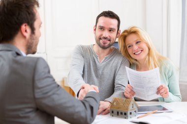 C imzalanmasından sonra el sıkışma emlakçı genç mutlu çift