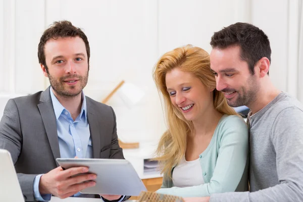 Real estate agent present project on tablet to a young couple — Stock Photo, Image