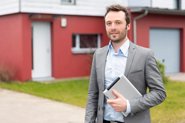 Porträtt av en ung fastighetsmäklare framför ett hus — Stockfoto