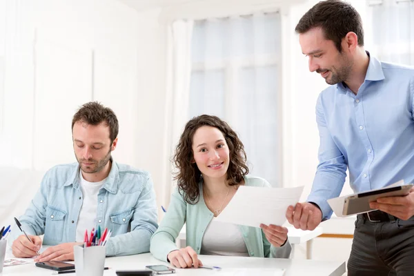 Two interns working together assisted by their course supervisor — Stock Photo, Image