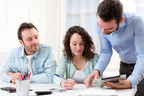 Two interns working together assisted by their course supervisor — Stock Photo, Image