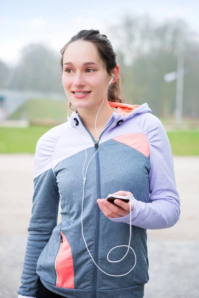 Young attractive woman adjust her music player before running — Stock Photo, Image