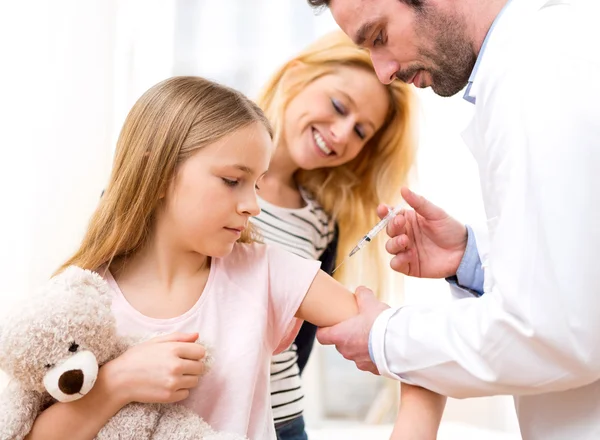 Young little girl  being vaccinated at the doctor Stock Image