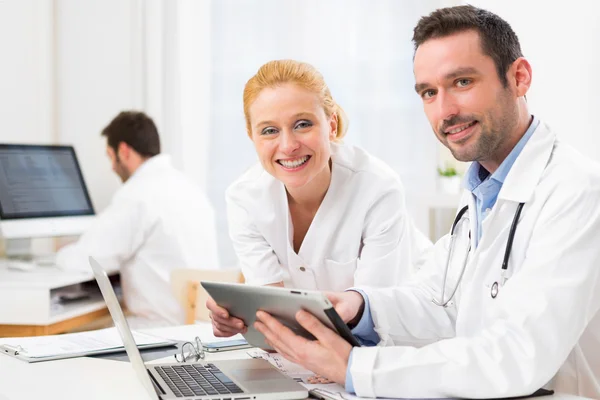 Doctor and an assistant working together at the hospital — Stock Photo, Image