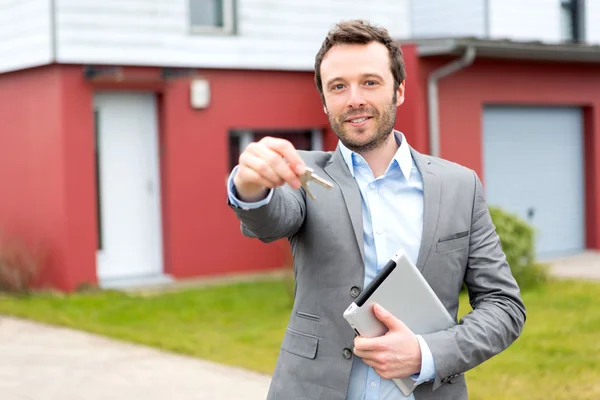 Porträt eines jungen Immobilienmaklers vor einem Haus — Stockfoto