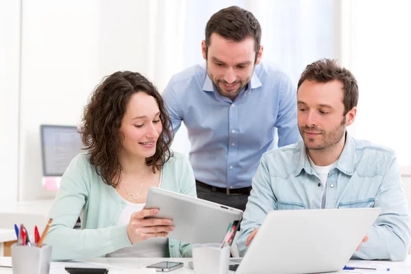 Zwei Praktikanten, die gemeinsam mit ihrem Kursleiter arbeiten — Stockfoto