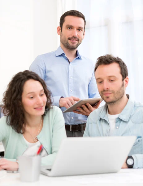 Zwei Praktikanten, die gemeinsam mit ihrem Kursleiter arbeiten — Stockfoto