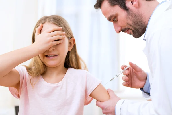 Niña joven siendo vacunada en el médico — Foto de Stock