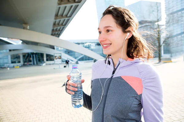 Donna che beve acqua durante una sessione di corsa — Foto Stock