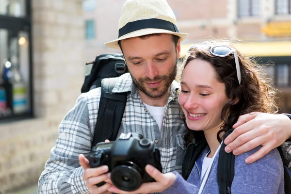 Mladý pár turistických sledováním fotografie na kameru — Stock fotografie