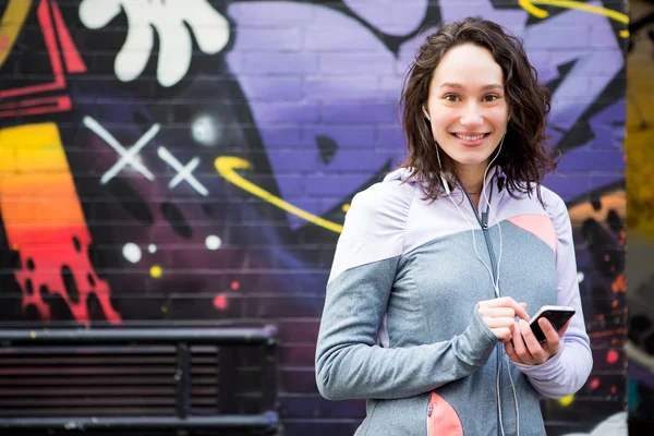 Young attractive woman adjust her music player before running — Stock Photo, Image