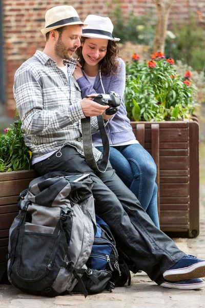 Young couple of tourist watching photographs during a break — Stock Photo, Image