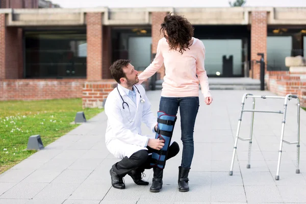 Junger Arzt hilft einer jungen Frau — Stockfoto