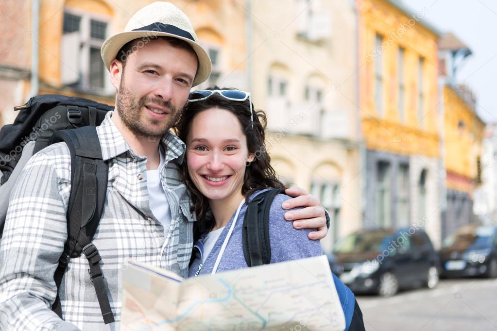 Couple of young attractive tourists watching map 