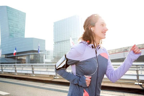 Jeune femme attrayante courir en ville — Photo