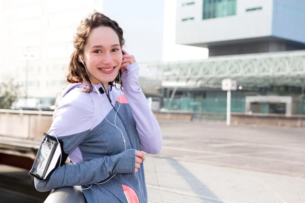 Young attractive woman adjust her music player before running — Stock Photo, Image