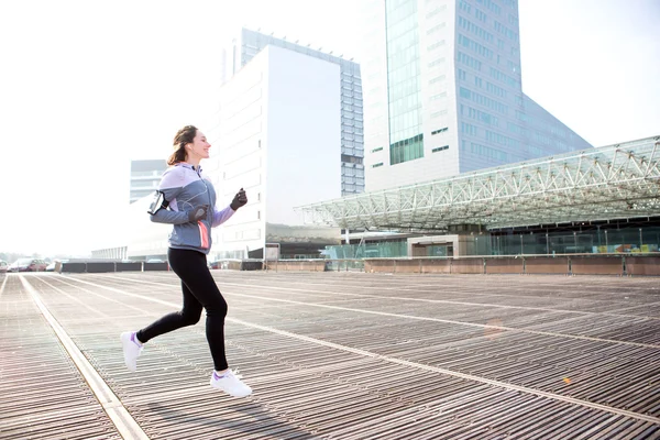Jovem mulher atraente correndo centro da cidade — Fotografia de Stock