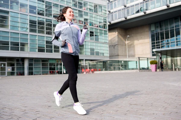 Jeune femme attrayante courir en ville — Photo