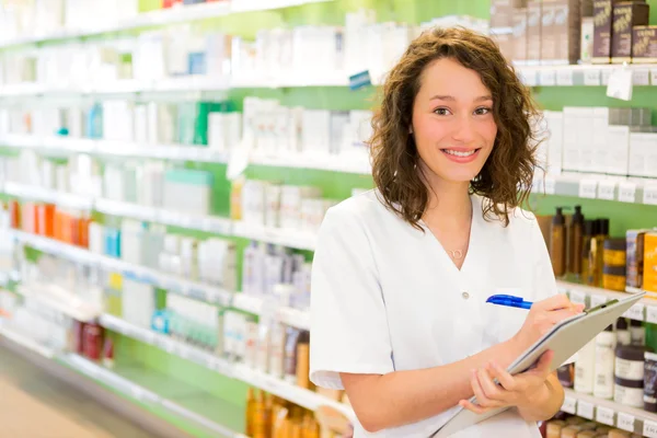 Attractive pharmacist taking notes at work — Stock Photo, Image