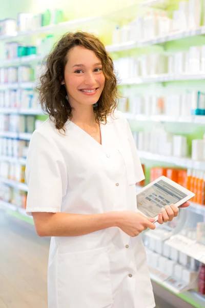 Attraktiver Apotheker mit Tablette bei der Arbeit — Stockfoto