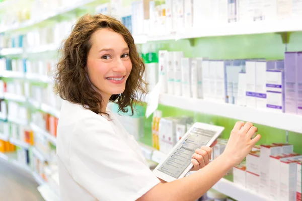 Attractive pharmacist using tablet at work — Stock Photo, Image