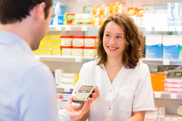 Attractive pharmacist taking healt insurance card — Stock Photo, Image
