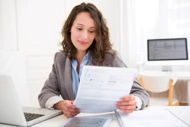 Young attractive woman doing paperwork clipart