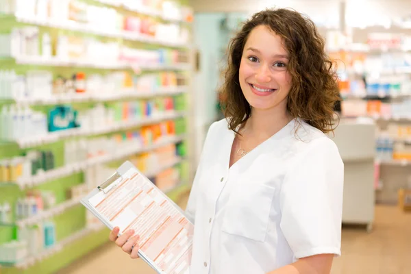 Attractive pharmacist taking notes at work — Stock Photo, Image