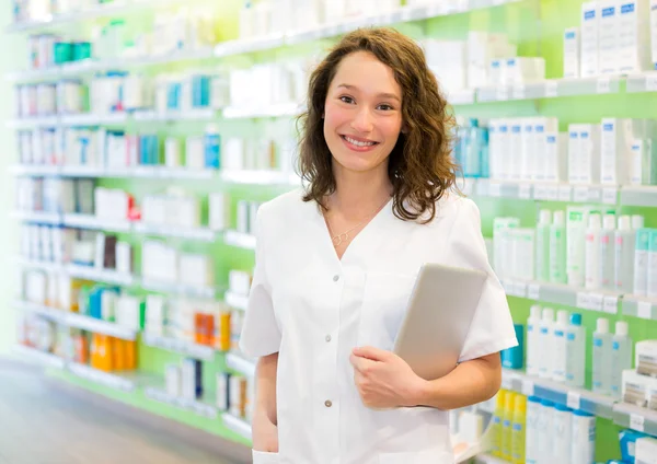 Attraktiver Apotheker mit Tablette bei der Arbeit — Stockfoto