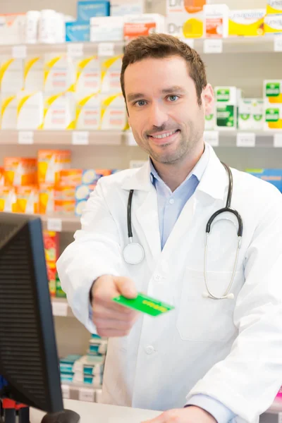 Attractive pharmacist taking healt insurance card — Stock Photo, Image