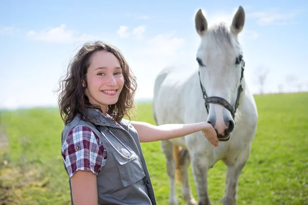 Portrait of a young attractive veterinary in fields with horse — Stock Photo, Image