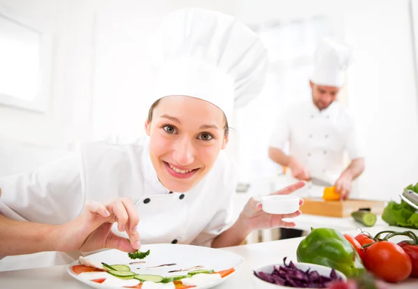 Giovane chef professionale attraente cucina nella sua cucina — Foto Stock